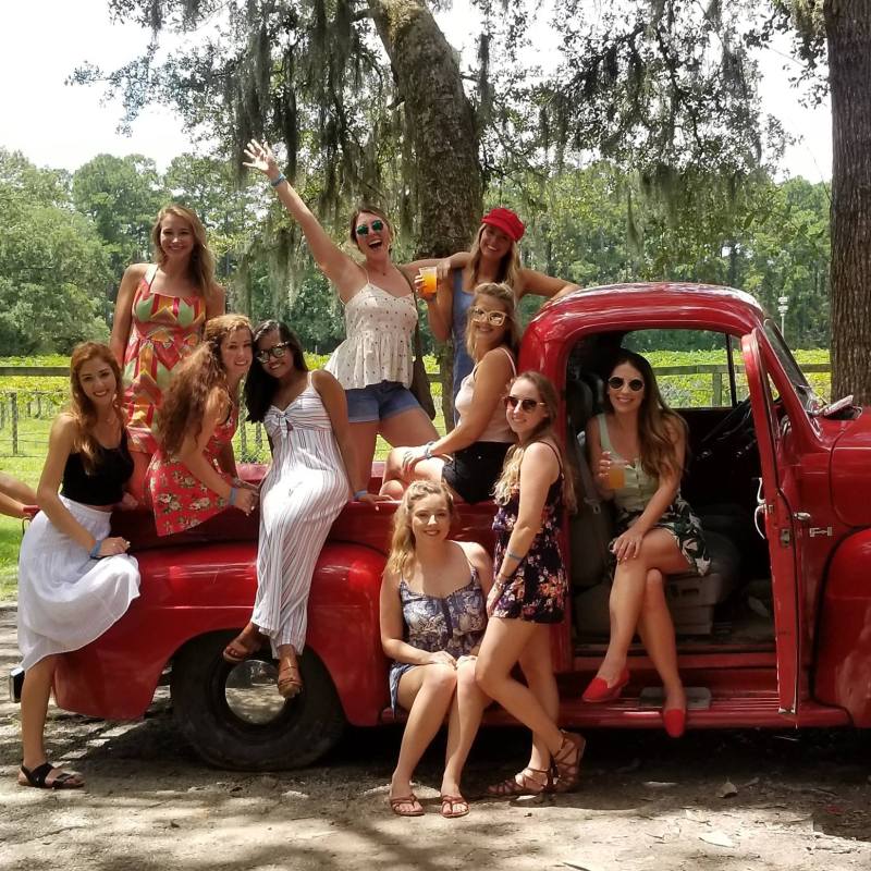 a group of people standing in front of a car posing for the camera