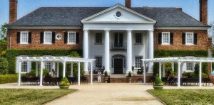 a large brick building with grass in front of a house